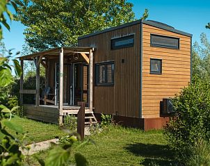 Houten exterieur van Vakantiehuis in Scherpenzeel, omringd door groen in Friesland.