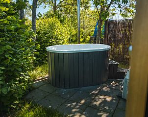 Relaxen in de hottub bij Vakantiehuisje in Scherpenzeel, omgeven door het Friese platteland.