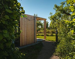 Ingang van Vakantiehuisje in Scherpenzeel, omgeven door groene natuur in Friesland.