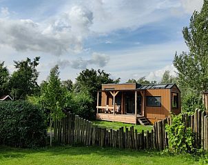 Huisje in Scherpenzeel, omringd door natuur op het Friese platteland.