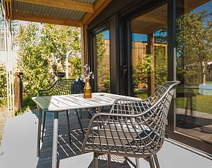 Gezellig terras met zitplaatsen bij Vakantiehuis in Scherpenzeel, omgeven door Friese natuur.