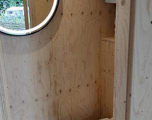 Stijlvolle badkamer met ronde spiegel in Vakantiehuis in Scherpenzeel, Friesland.