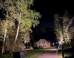 Huisje in Blesdijke, nachtelijke ambiance van safaritenten in het Friese platteland, omringd door natuur.
