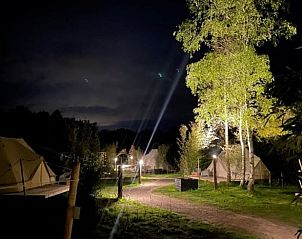 Huisje in Blesdijke, wandelpad langs verlichte safaritenten in het rustige Friese landschap.