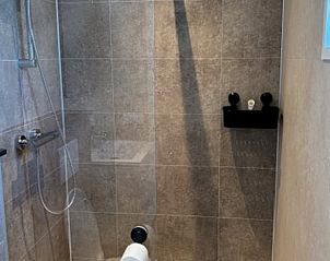 Moderne badkamer in Huisje in Blesdijke, vakantiehuis op het Friese platteland, Friesland, met luxe douche en stijlvolle tegelafwerking.