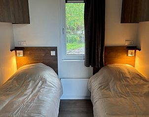 Tweepersoonskamer in Vakantiehuis in Blesdijke met comfortabele bedden en sfeerverlichting.