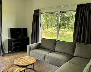 Ruime woonkamer in Vakantiehuis in Blesdijke met groot raam en groen uitzicht.