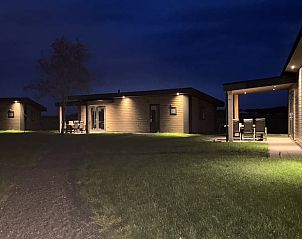 Vakantiehuisje in Blesdijke verlicht in de avond op het Friese platteland.