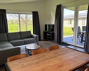 Veranda en woonkamer in Vakantiehuis in Blesdijke met uitzicht op het Friese platteland.