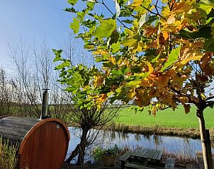 Vakantiehuisje in Easterein met sauna en herfstkleuren naast een kanaal in Friesland.