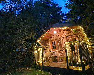 Vakantiehuisje in Easterein met sfeervolle veranda verlicht in de avond in Friesland.