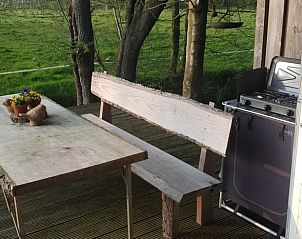 Houten veranda van Vakantiehuisje in Rinsumageast, ideaal voor buiten dineren in Friesland.