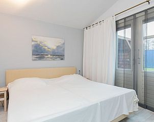 Slaapkamer in Vakantiehuisje in Rinsumageast met comfortabel tweepersoonsbed en natuurlijk licht.