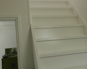 Witte trap naar boven in Vakantiehuisje in Poppenwier, Friese platteland, Friesland.