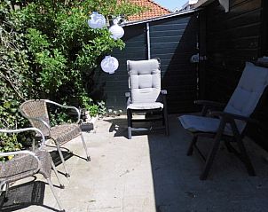 Zonnig terras met stoelen bij Vakantiehuisje in Poppenwier, Friese platteland, Friesland.