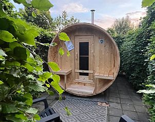 Houten buitensauna bij Vakantiehuisje in Poppenwier, omgeven door groen.