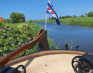 Prachtig uitzicht vanaf Huisje in Poppenwier, vakantiehuis in Friesland, met Friese vlag aan het water.