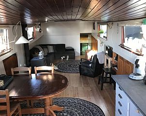 Interieur van Huisje in Poppenwier, vakantiehuis in Friesland, met eet- en zithoek in warme sfeer.