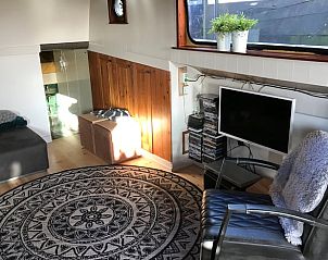 Knusse woonkamer in Huisje in Poppenwier, vakantiehuis in Friesland, met televisie en leeshoek.