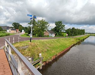 Uitzicht vanaf de brug op de rustige omgeving van Huisje in Driezum, een vakantiehuis in het Friese platteland.