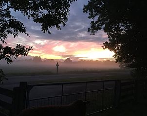 Adembenemende zonsondergang bij Vakantiehuisje in Mantgum, Friesland, met mistige velden en kleurrijke luchten.