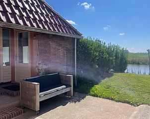 Rustieke veranda van Huisje in Hallum met uitzicht op het Friese platteland.