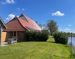 Huisje in Hallum gelegen aan een rustige waterkant in het Friese landschap.
