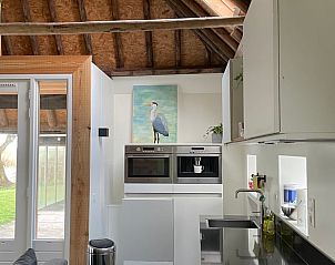 Moderne keuken in Huisje in Hallum met strakke lijnen en kunst aan de muur.