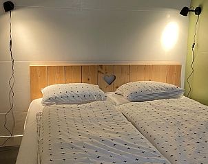 Sfeervolle slaapkamer in Huisje in Hallum met houten accenten en zachte verlichting.