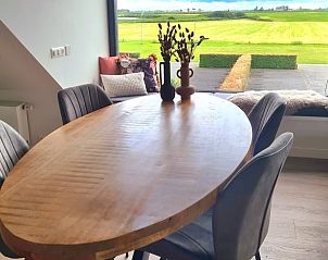 Houten eettafel in Vakantiehuisje in Westhem met panoramisch uitzicht op het Friese platteland, Friesland.