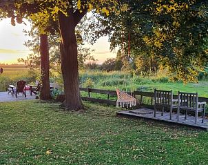 Gezellig terras bij Vakantiehuis in Bantega, Friesland, met uitzicht op het platteland bij zonsondergang.