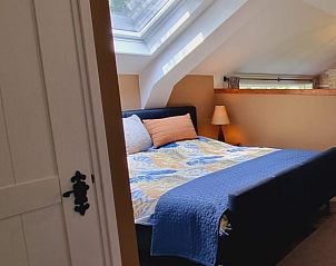 Sfeervolle slaapkamer in Vakantiehuis in Bantega, Friesland, met dakraam voor natuurlijk licht.