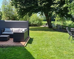 Zonnig terras met comfortabele zitplaatsen bij Vakantiehuis in Bantega, Friesland, voor buitenplezier.