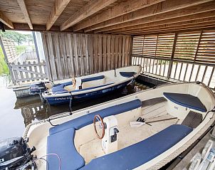 Overdekte ligplaats met boten bij chalet Sluisje 14 in Bantega, ideaal voor waterliefhebbers in het Friese platteland.