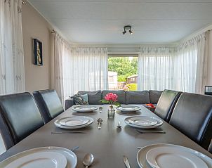 Eettafel gedekt voor zes personen in chalet Sluisje 54, Bantega, met uitzicht op de tuin.