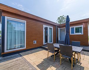 Zonnig terras met parasol bij vakantiehuis Sluisje 54, Bantega, Friesland.