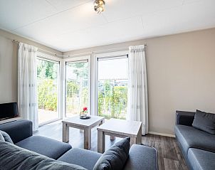 Gezellige woonkamer in chalet Sluisje 15, Bantega, met uitzicht op het Friese landschap.