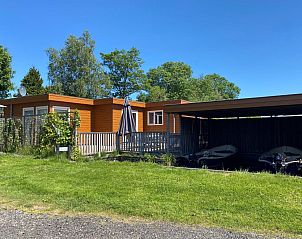 Zijaanzicht van chalet Sluisje 15, Bantega, Friesland, met terras en boten.