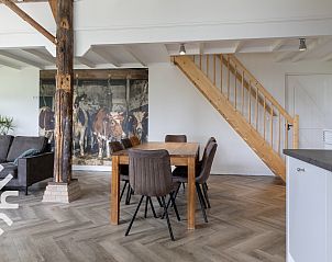 Gezellig terras bij FR449 vakantiehuis in Bantega, Friesland met bomen en bloemen.