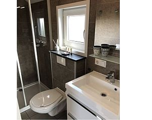 Badkamer van Huisje in Greonterp met moderne douche en wastafel, Friesland.