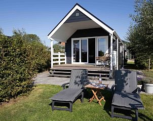 Terras van Huisje in Greonterp met ligstoelen en groene omgeving, Friesland.