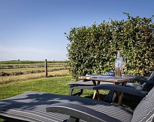 Ligstoelen in de tuin van Huisje in Greonterp met uitzicht op het platteland, Friesland.