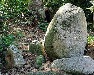Grote stenen in de tuin van Vakantiehuis in Oldeholtpade, omgeven door natuur.