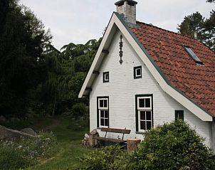 Rustiek wit vakantiehuis in Oldeholtpade, Friesland met groene omgeving.