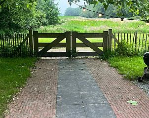 Sfeervolle tuinpoort bij Vakantiehuisje in Oldeholtpade, toegang tot het Friese platteland in Friesland.