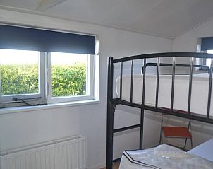 Ruime slaapkamer met stapelbed in Vakantiehuisje in Ferwoude, met uitzicht op het Friese platteland.