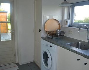 Praktische bijkeuken in Vakantiehuisje in Ferwoude met wasmachine en toegang tot tuin in Friesland.