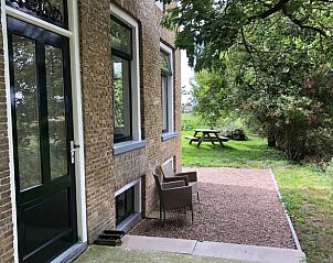 Veranda van Huisje in Wijnaldum, vakantiehuis in Friesland, omgeven door natuur.