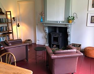 Gezellige woonkamer met open haard in Huisje in Wijnaldum, vakantiehuis Friesland.