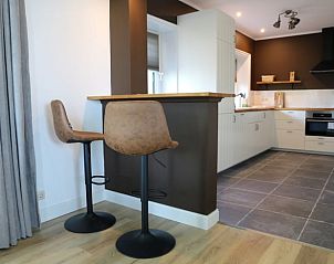 Moderne keuken met bar in Huisje in Wijnaldum, vakantiehuis op het Friese platteland.